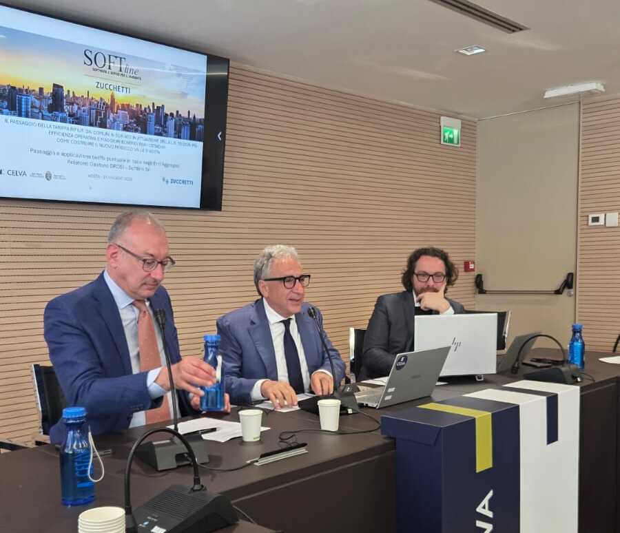 L'immagine di un convegno con tre relatori seduti a un tavolo